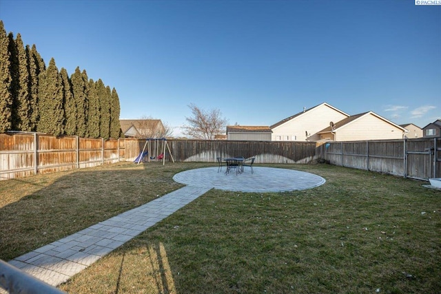 view of yard with a fenced backyard, a patio, and a playground