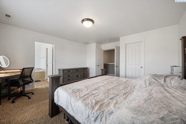 carpeted bedroom featuring a closet, visible vents, and connected bathroom