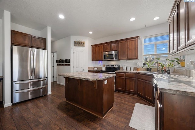 kitchen featuring a center island, dark wood finished floors, recessed lighting, appliances with stainless steel finishes, and a textured ceiling