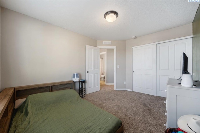 carpeted bedroom with a textured ceiling, a closet, visible vents, and baseboards