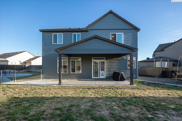 back of property featuring a yard, fence, and a patio