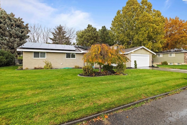 ranch-style home featuring a garage, a front lawn, and solar panels