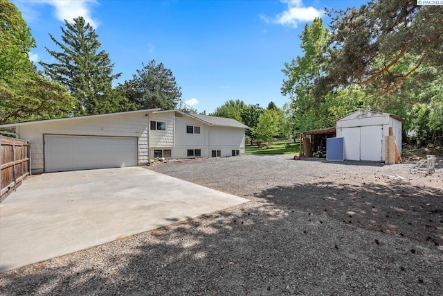 7009 W 8th Ave, Kennewick, WA 99336 - view of side of home with a shed, driveway, view of scattered trees, and an outdoor structure