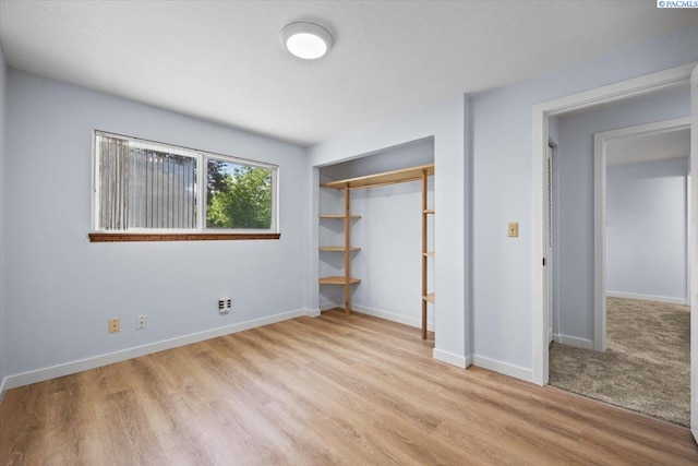 7009 W 8th Ave, Kennewick, WA 99336 - unfurnished bedroom featuring a closet, baseboards, and light wood-style floors