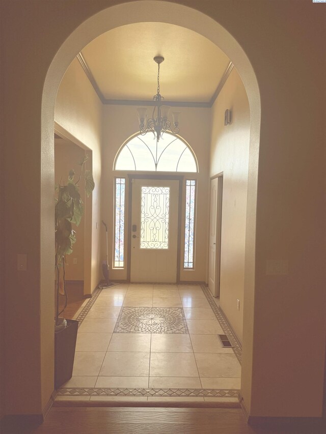 483 Aimee Dr, Richland, WA 99352 - entryway featuring arched walkways, ornamental molding, light tile patterned floors, inlaid floor details, and a chandelier