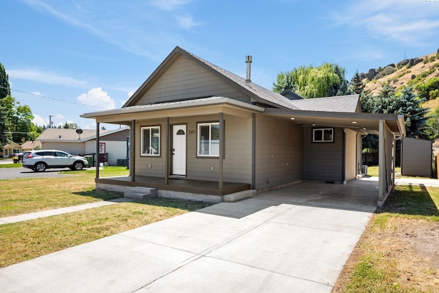 205 W 8th St, Colfax, WA 99111 - view of front of home featuring an attached carport, a porch, a front lawn, and driveway