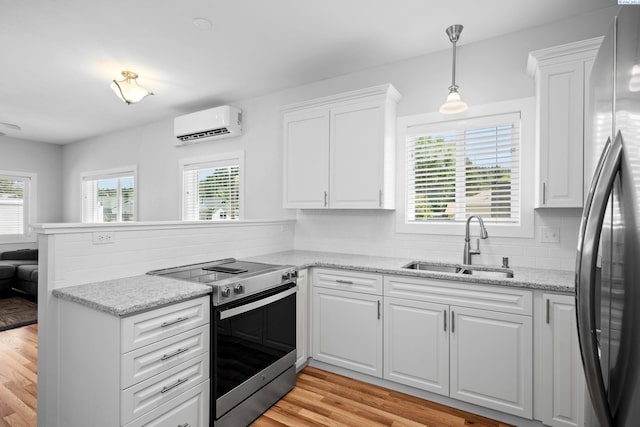 205 W 8th St, Colfax, WA 99111 - kitchen with appliances with stainless steel finishes, a wall mounted AC, a peninsula, and plenty of natural light