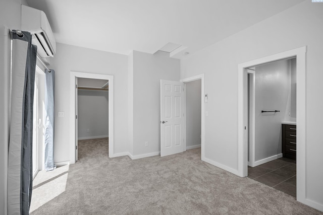 205 W 8th St, Colfax, WA 99111 - unfurnished bedroom featuring a wall mounted AC, carpet floors, a walk in closet, ensuite bathroom, and a closet
