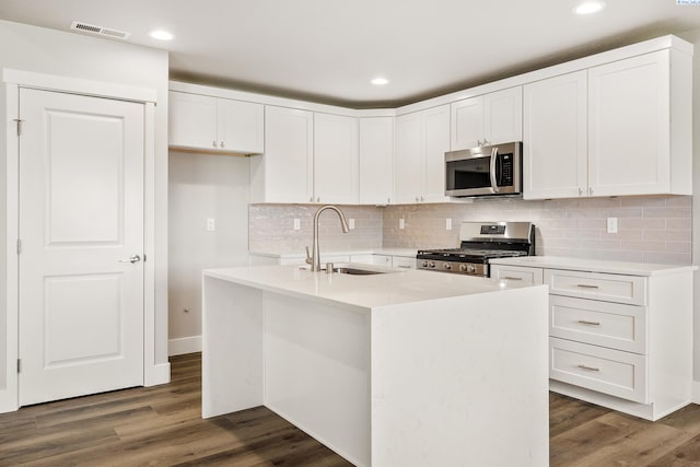 3054 S Quay St, Kennewick, WA 99338 - kitchen with appliances with stainless steel finishes, white cabinets, light countertops, tasteful backsplash, and dark wood-style flooring