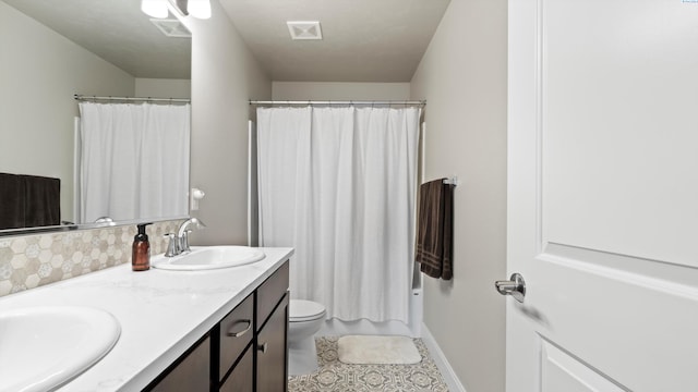 full bathroom with double vanity, a sink, tasteful backsplash, and toilet