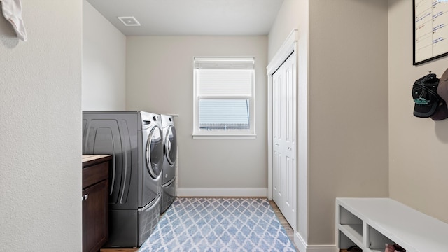 washroom with independent washer and dryer, baseboards, laundry area, and visible vents