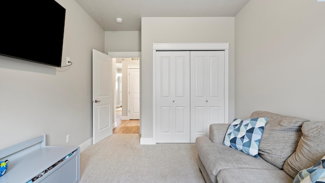 living area with baseboards and light colored carpet