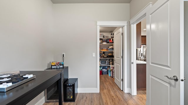 office featuring baseboards, light wood-style flooring, and wine cooler