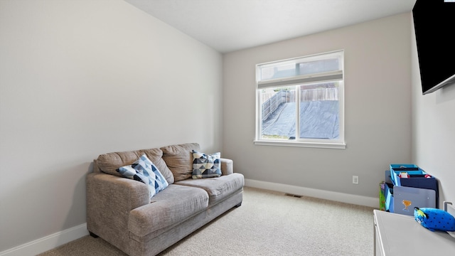 sitting room with carpet floors, baseboards, and visible vents