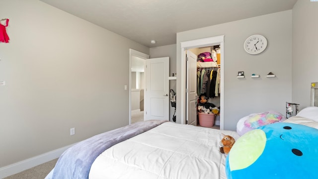 bedroom with baseboards, a walk in closet, a closet, and carpet