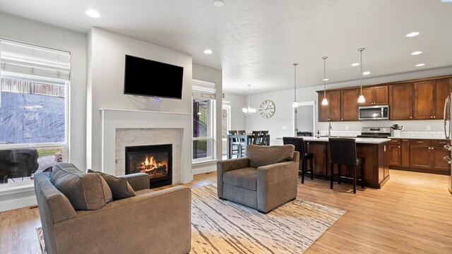 living room with plenty of natural light, light wood-type flooring, and a glass covered fireplace