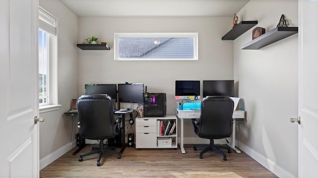 office area with baseboards, a healthy amount of sunlight, and wood finished floors