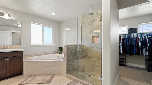 bathroom featuring a bath, baseboards, a stall shower, and vanity
