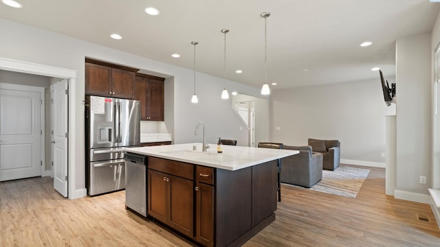 kitchen with a sink, light wood-style flooring, stainless steel appliances, recessed lighting, and dark brown cabinets