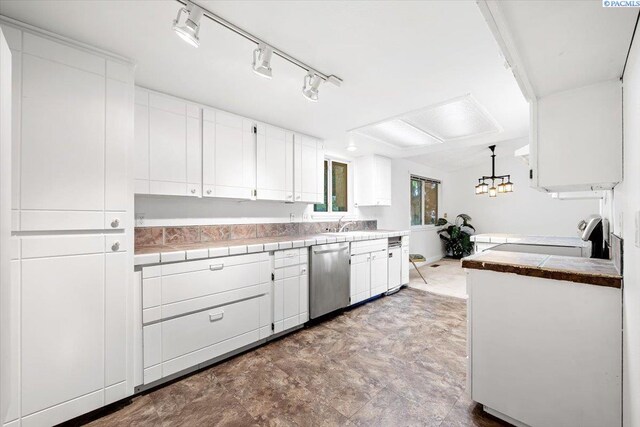 kitchen with white cabinetry, stainless steel dishwasher, track lighting, tile counters, and pendant lighting