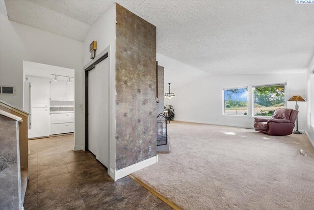 corridor featuring dark carpet, vaulted ceiling, and a textured ceiling