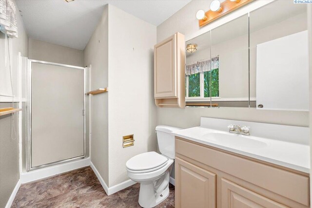 bathroom featuring vanity, toilet, and an enclosed shower