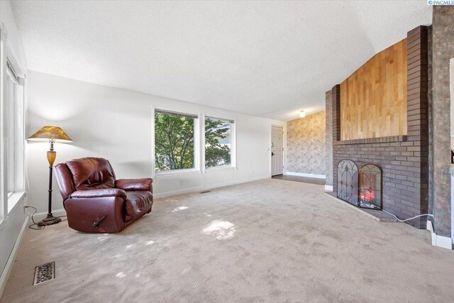 carpeted living room with a fireplace, vaulted ceiling, and a textured ceiling