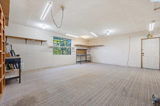 basement featuring light carpet and a textured ceiling