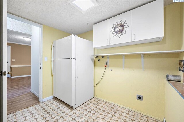 laundry area with cabinets, a textured ceiling, and electric dryer hookup