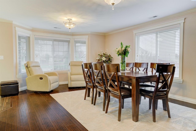 dining area featuring wood-type flooring and ornamental molding