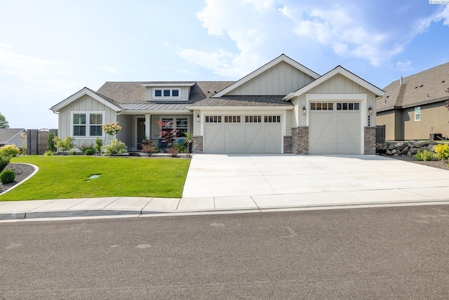 craftsman inspired home featuring an attached garage, stone siding, driveway, a front lawn, and board and batten siding