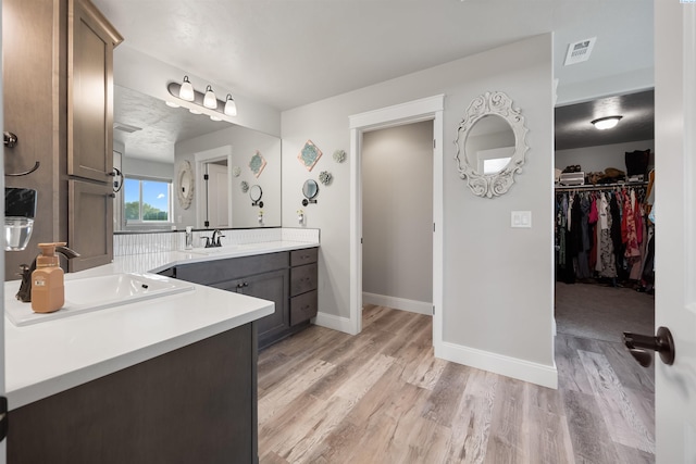 5901 W Ruby St, Pasco, WA 99301 - full bathroom with wood finished floors, two vanities, baseboards, and a walk in closet