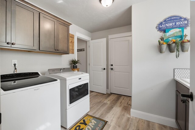 5901 W Ruby St, Pasco, WA 99301 - laundry area with washer and clothes dryer, baseboards, cabinet space, and light wood-style flooring