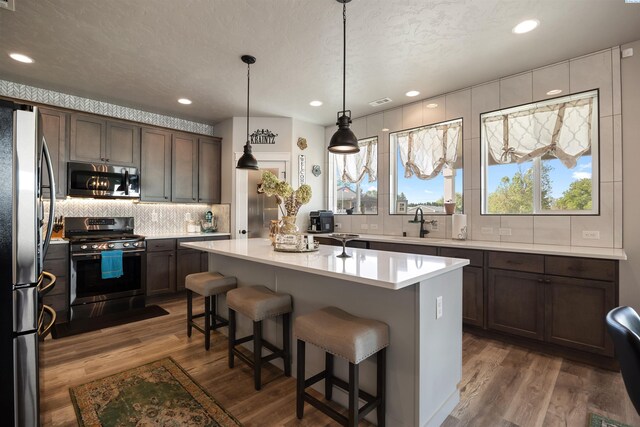 5901 W Ruby St, Pasco, WA 99301 - kitchen with stainless steel appliances, decorative backsplash, dark wood finished floors, light countertops, and recessed lighting