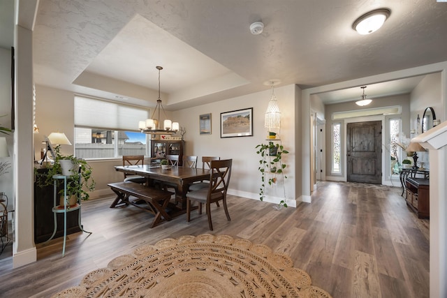5901 W Ruby St, Pasco, WA 99301 - dining area with baseboards, wood finished floors, a tray ceiling, and a chandelier