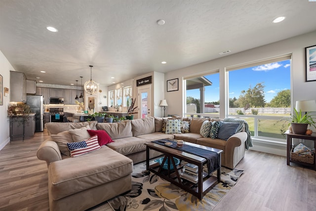 5901 W Ruby St, Pasco, WA 99301 - living area featuring a chandelier, recessed lighting, light wood-style flooring, and baseboards