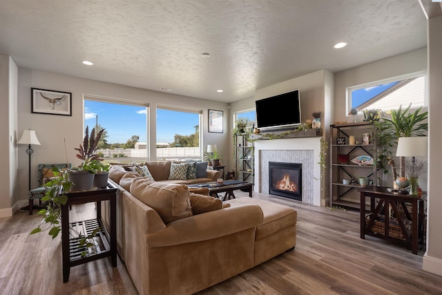 5901 W Ruby St, Pasco, WA 99301 - living room with a glass covered fireplace, wood finished floors, baseboards, recessed lighting, and a textured ceiling