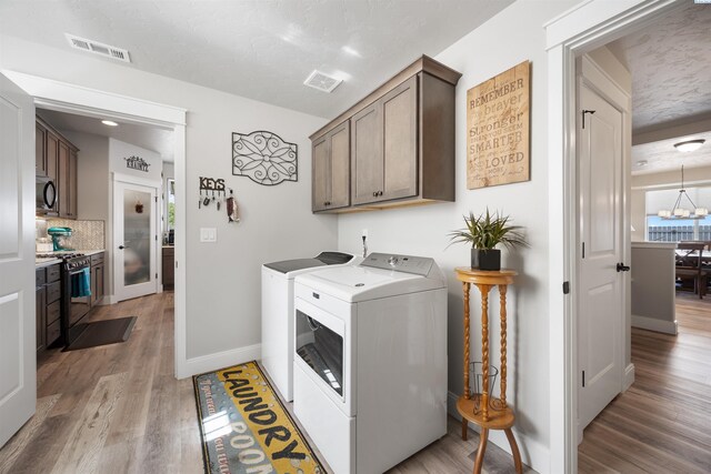 5901 W Ruby St, Pasco, WA 99301 - laundry room featuring washer and dryer, cabinet space, light wood-style floors, and baseboards