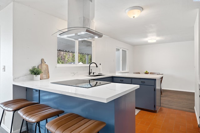 2128 Shasta Ave, Richland, WA 99354 - kitchen with island exhaust hood, a peninsula, black electric cooktop, brick floor, and a sink