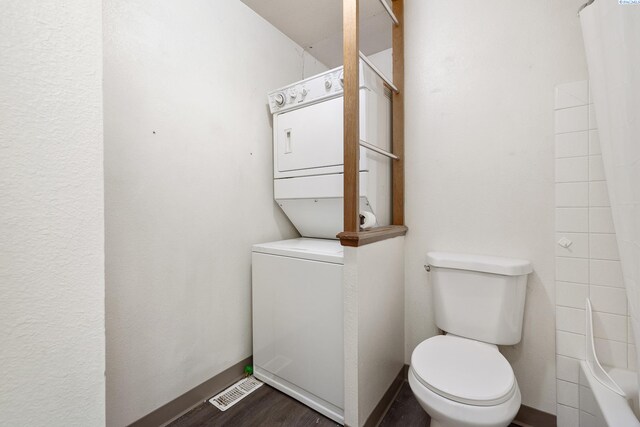 2128 Shasta Ave, Richland, WA 99354 - full bath with baseboards, toilet, a shower, stacked washer and clothes dryer, and wood finished floors