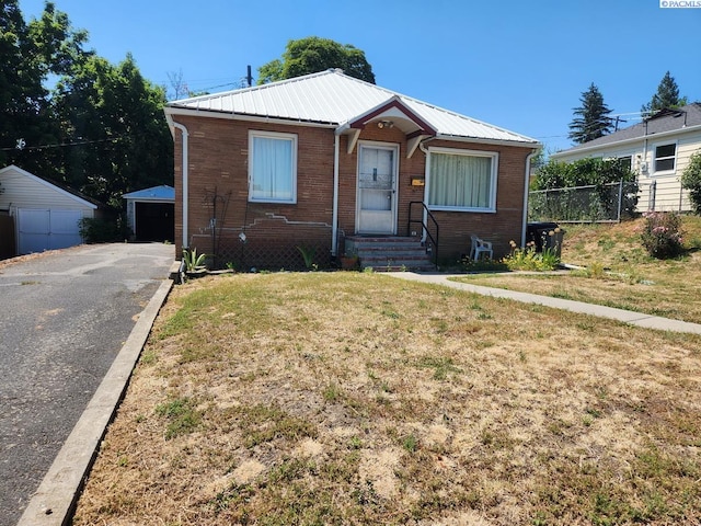 bungalow featuring a garage and a front lawn