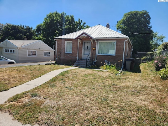 bungalow-style home with a front yard