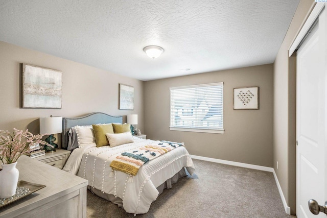 carpeted bedroom with a closet, a textured ceiling, and baseboards