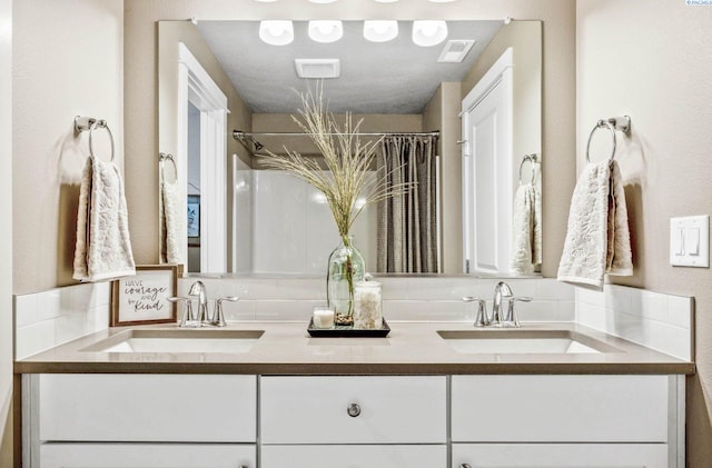 bathroom featuring double vanity, a sink, and visible vents