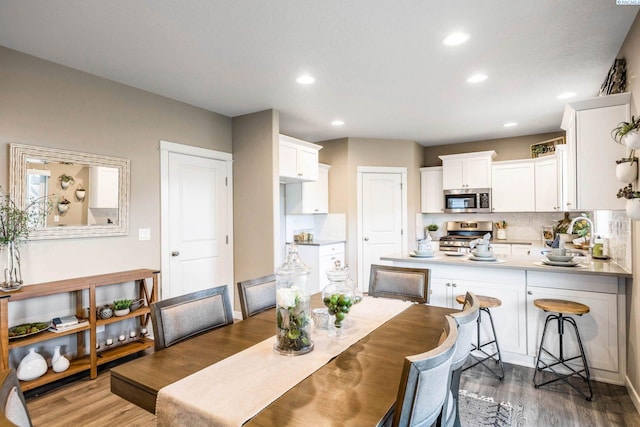 dining room with dark wood-style flooring and recessed lighting