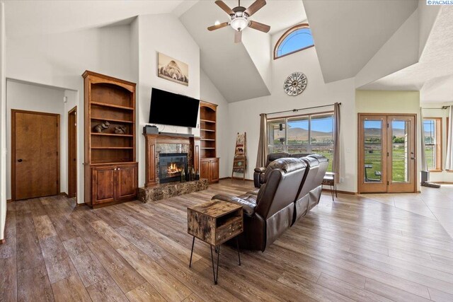 19408 Quail Run Pr SW, Prosser, WA 99350 - living room with high vaulted ceiling, a ceiling fan, a glass covered fireplace, and hardwood / wood-style flooring