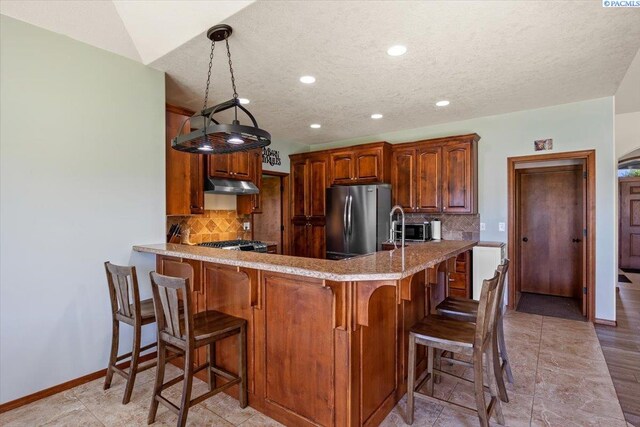 19408 Quail Run Pr SW, Prosser, WA 99350 - kitchen with freestanding refrigerator, under cabinet range hood, recessed lighting, backsplash, and a peninsula