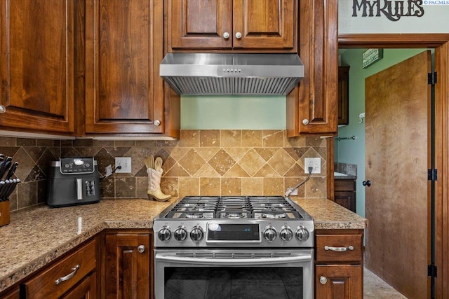 19408 Quail Run Pr SW, Prosser, WA 99350 - kitchen featuring stainless steel gas range, exhaust hood, tasteful backsplash, and light countertops