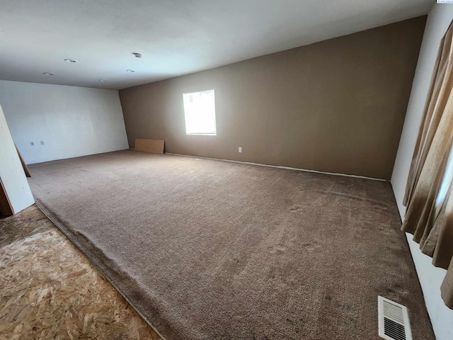 carpeted spare room featuring visible vents