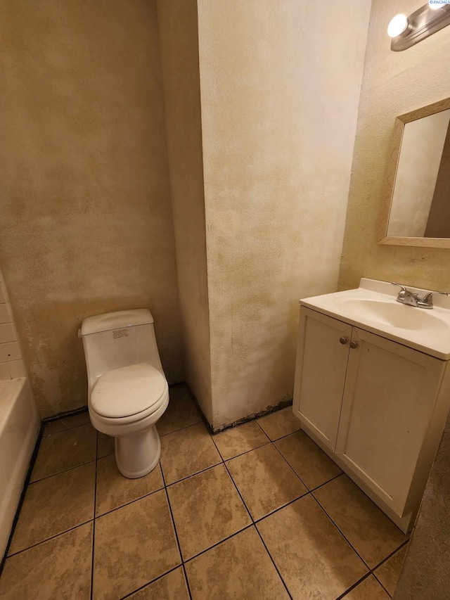 bathroom featuring tile patterned floors, vanity, toilet, and a bathtub